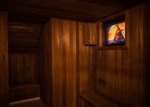 In the back of the dry sauna is a dark room. This dry sauna also features a TV playing the hottest movies.