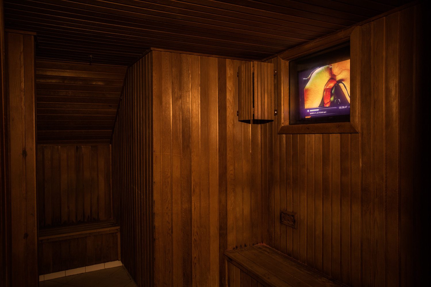 In the back of the dry sauna is a dark room. This dry sauna also features a TV playing the hottest movies.